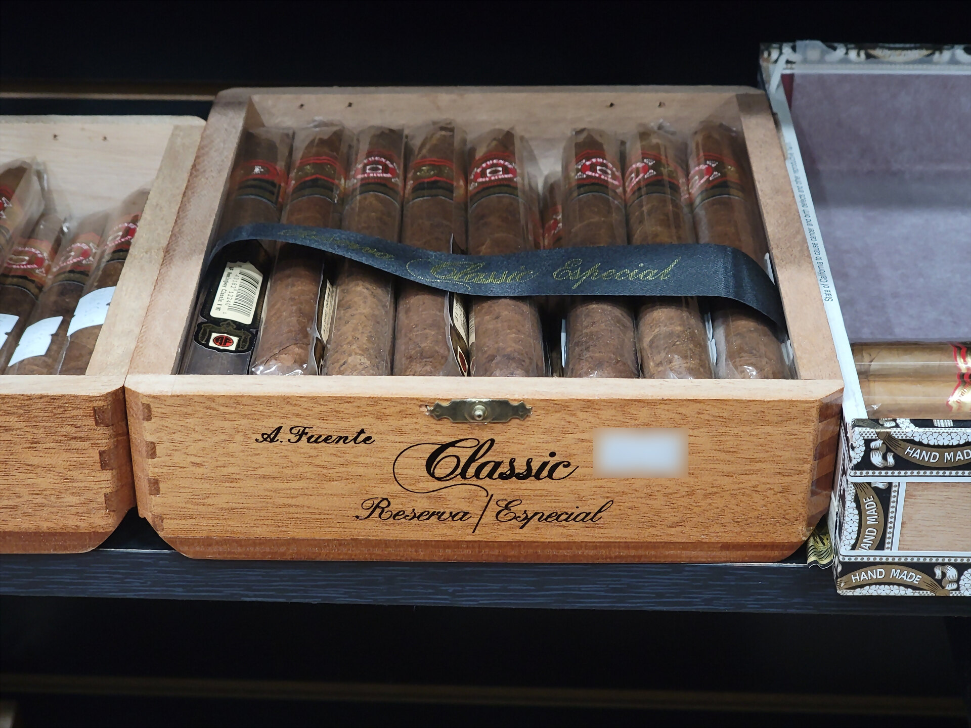 An Arturo Fuente Hemingway Classic box open on the shelf, the ribbon still laid across the cigars