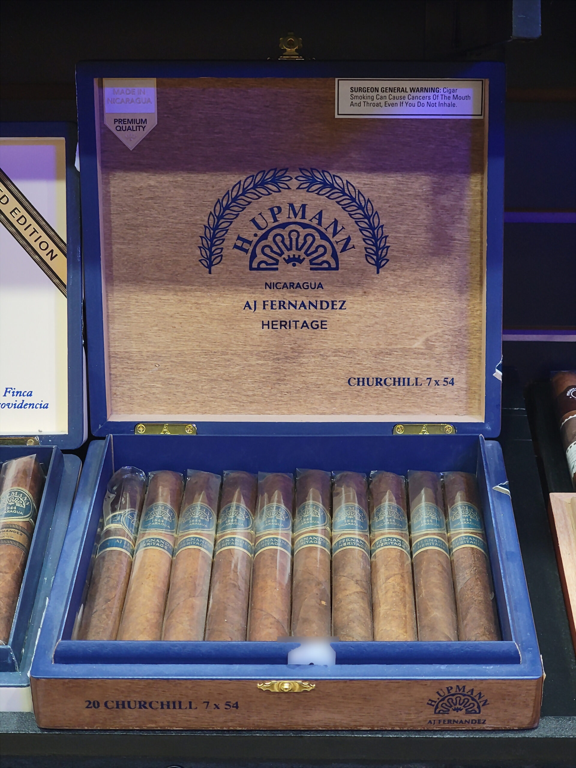 An H. Upmann by AJ Fernandez Heritage box open, 20 CHURCHILL 7 x 54 on the front rail