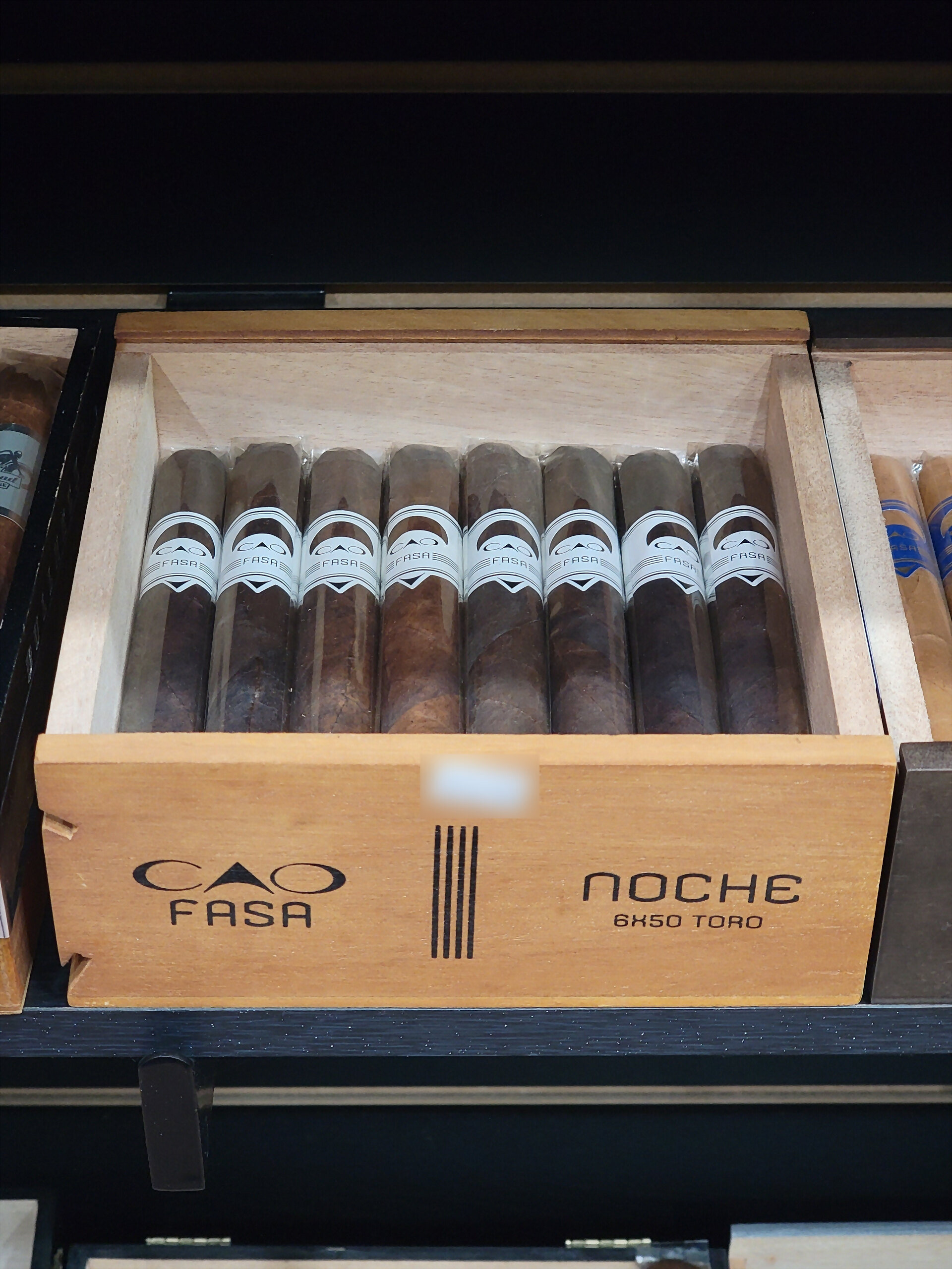 A CAO Fasa Noche box open on the shelf, NOCHE 6X50 TORO on the front rail