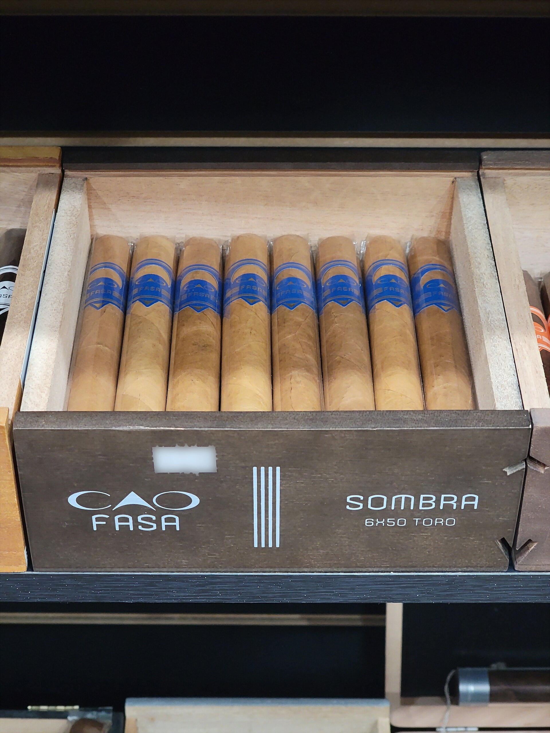A CAO Fasa Sombra box open on the shelf, SOMBRA 6X50 TORO on the front rail