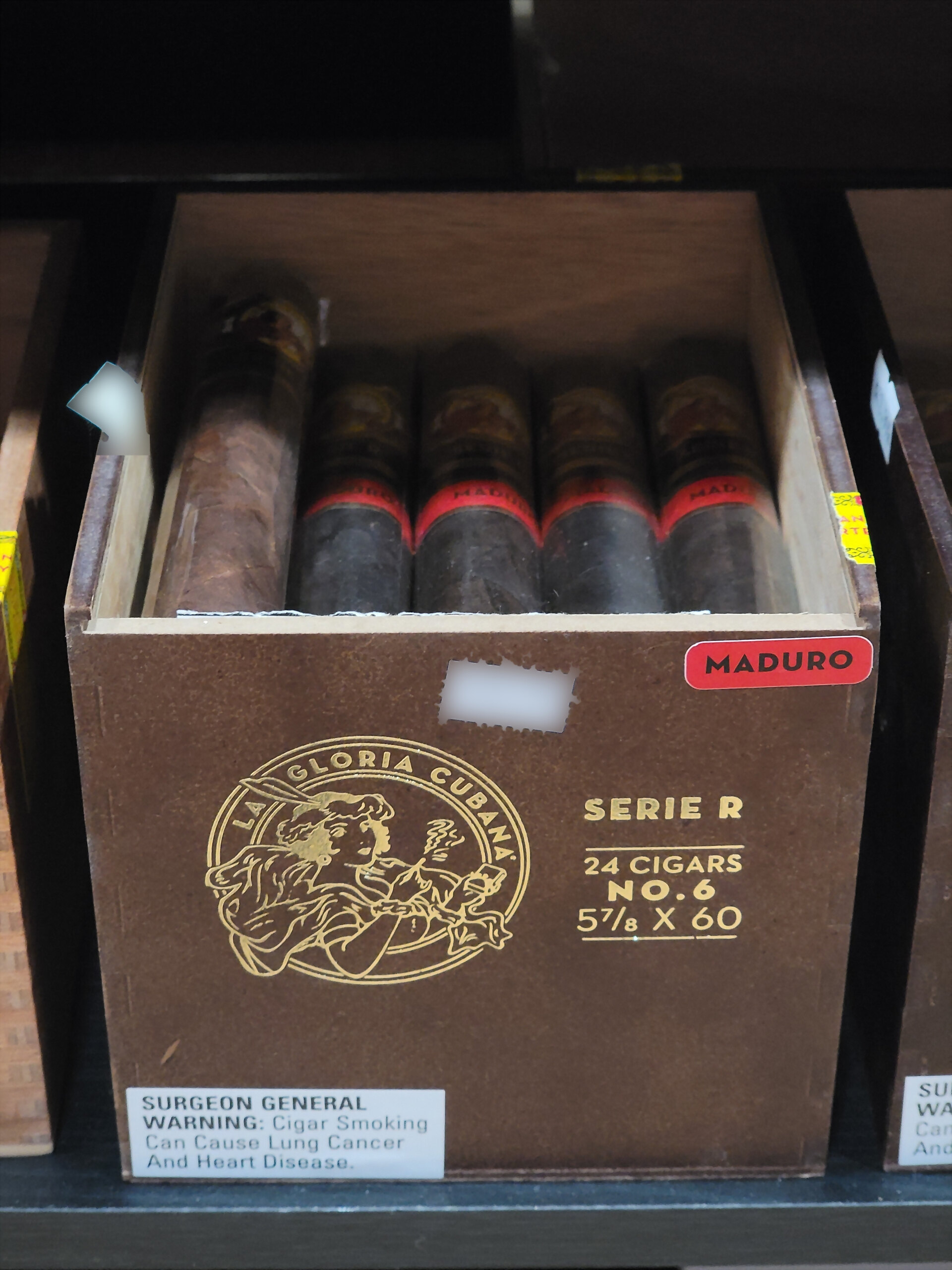The Serie R No. 6 box open on the shelf, red-banded cigars laid in rows