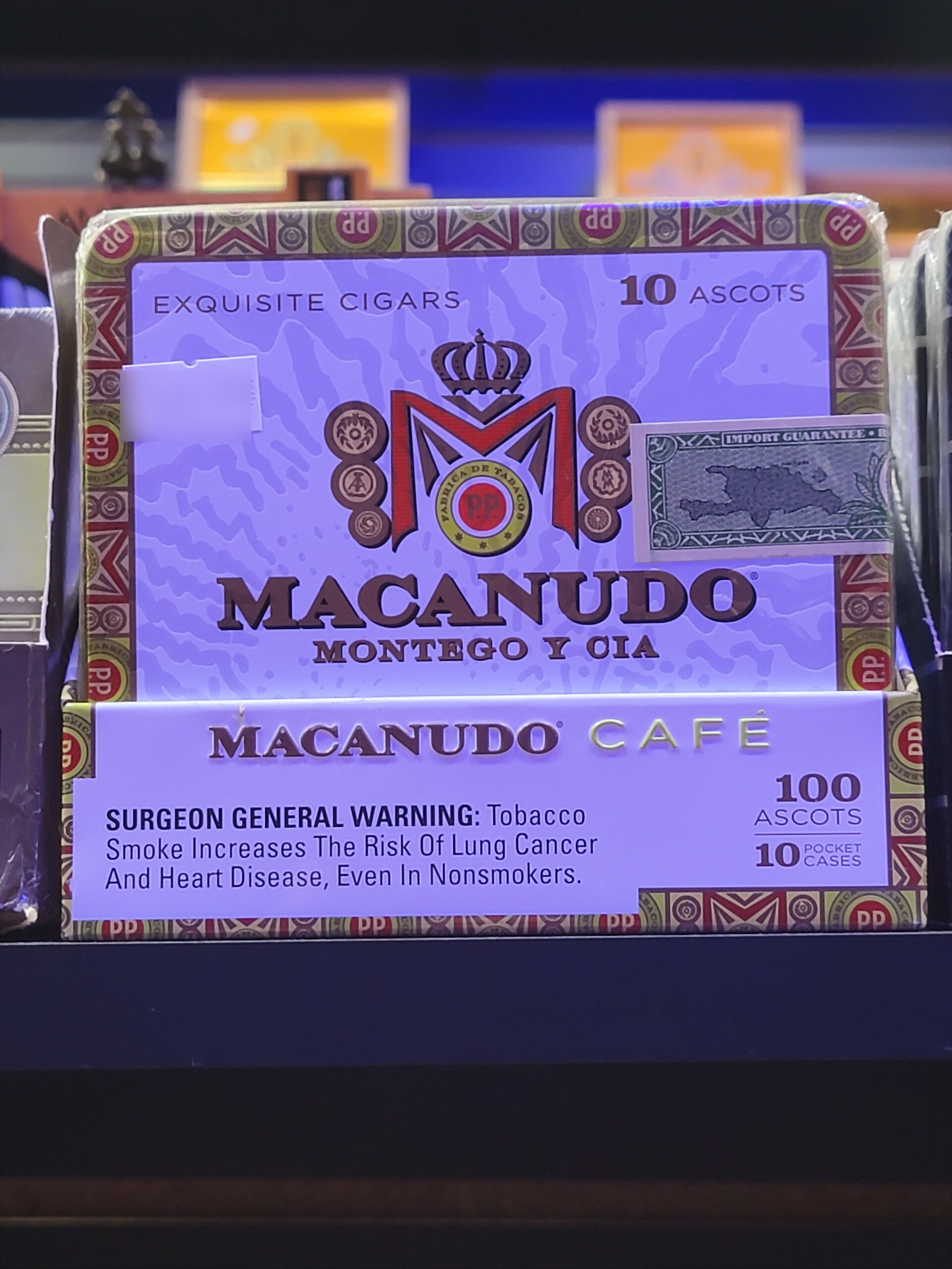 A Macanudo Café carton, 10 ASCOTS and 100 ASCOTS / 10 POCKET CASES printed on the front