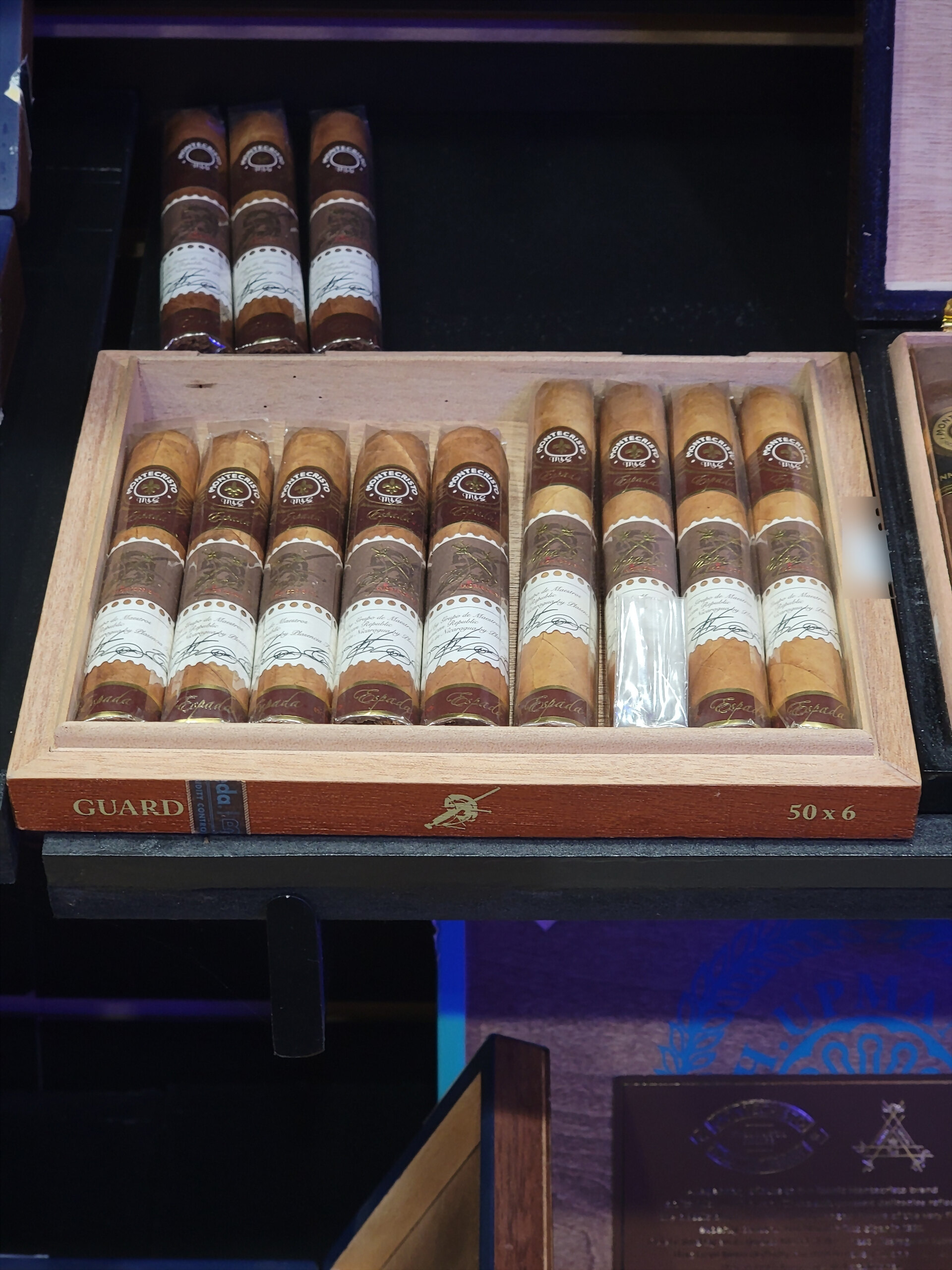 A Montecristo Espada box open on the shelf, GUARD and 50 x 6 on the front rail