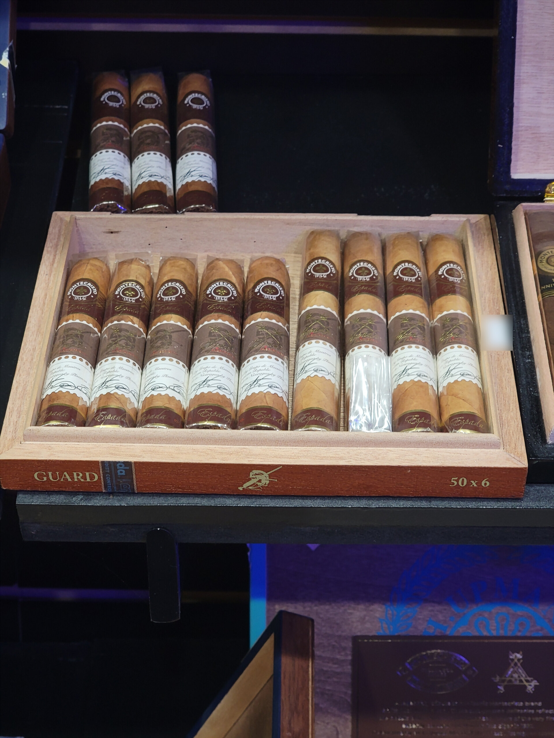 A Montecristo Espada Guard box open on the shelf, GUARD and 50 x 6 on the front rail