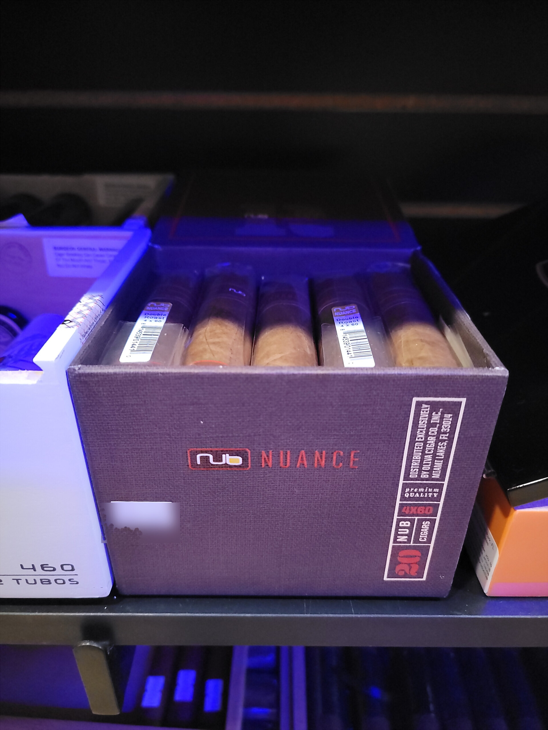 A purple Nub Nuance box open on the humidor shelf, the nub logo across the front