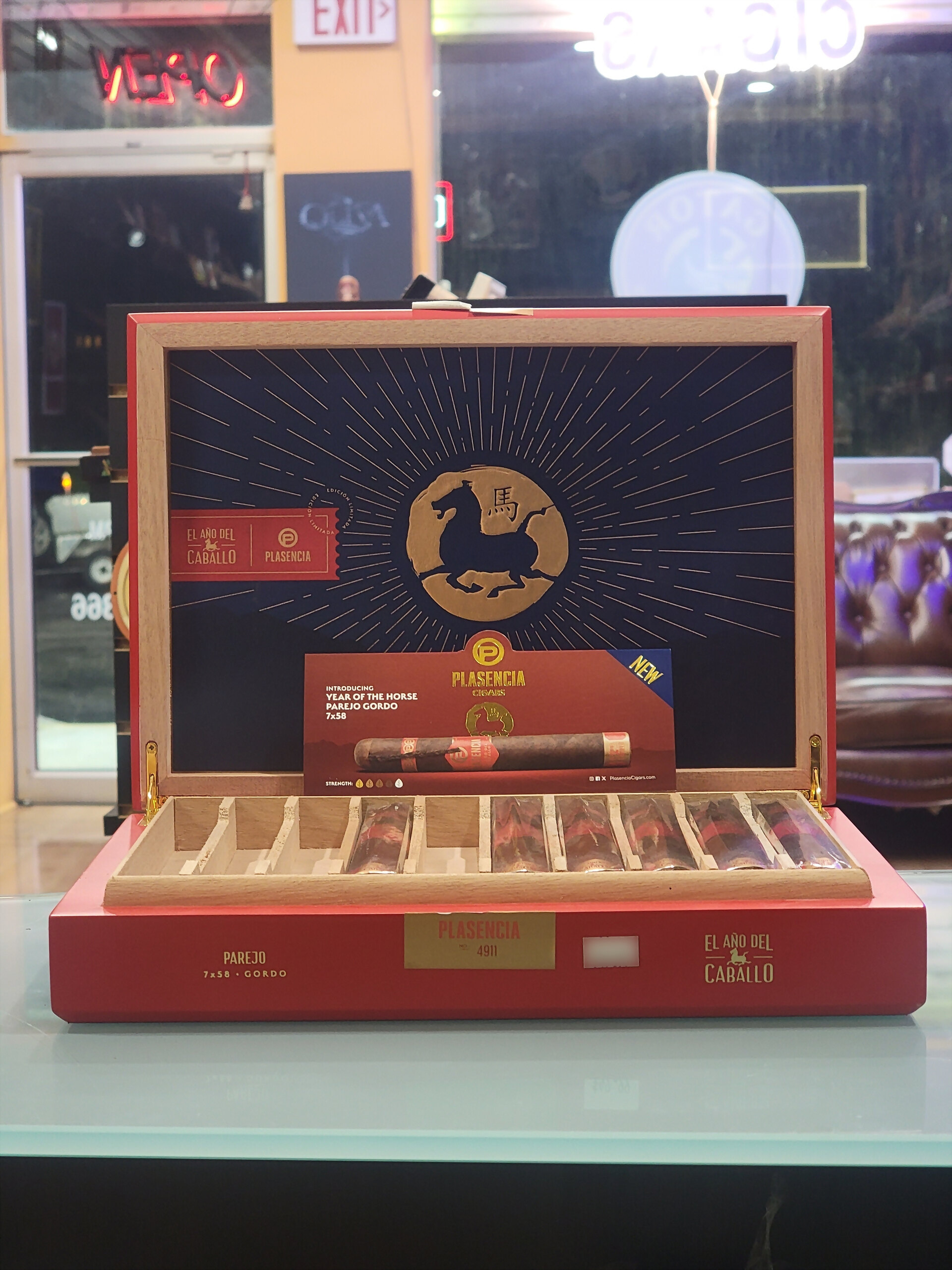 The El Año del Caballo box standing open on the counter glass, the shopfront behind it