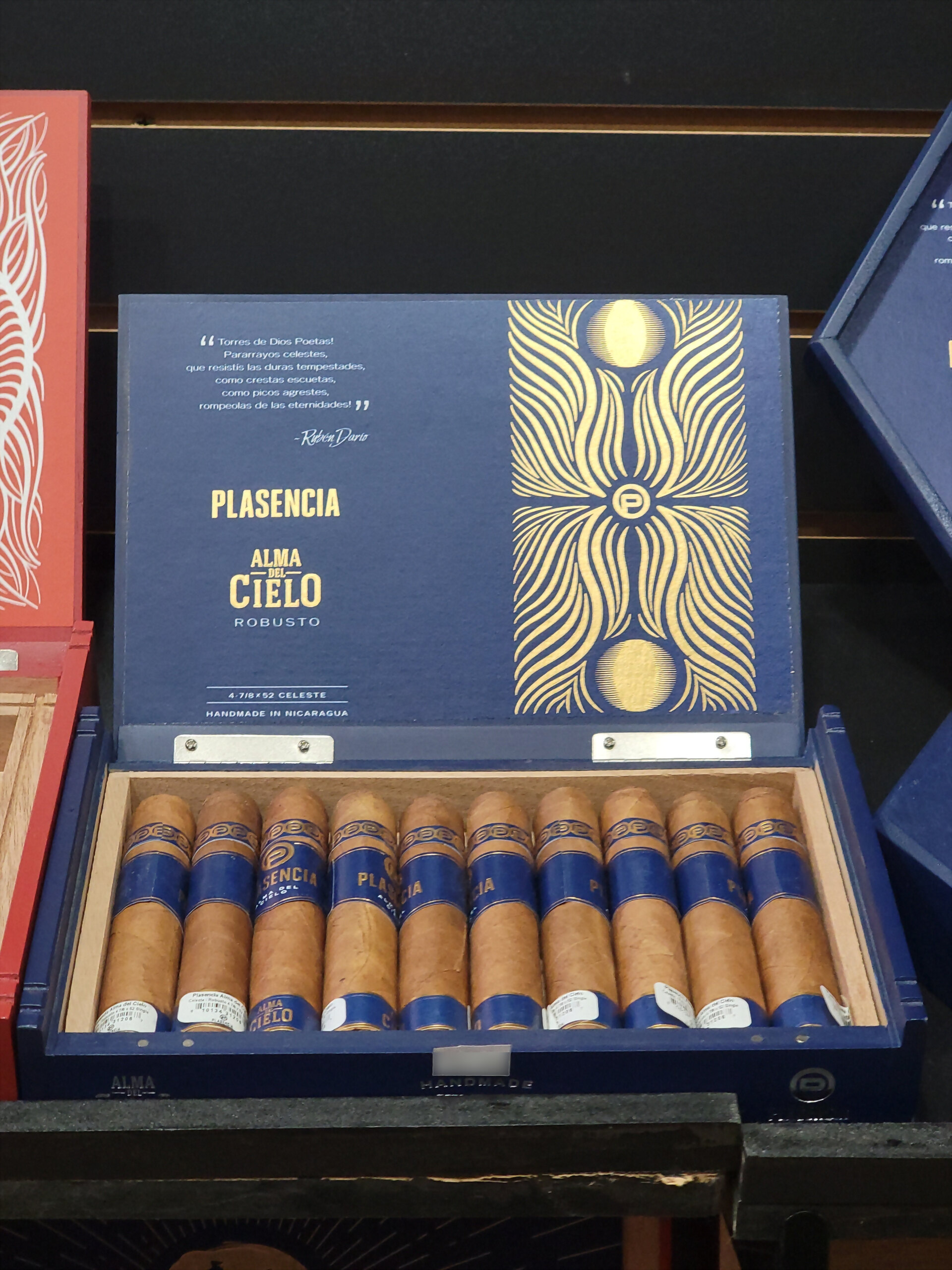 A blue Plasencia Alma del Cielo Robusto box open on the humidor shelf