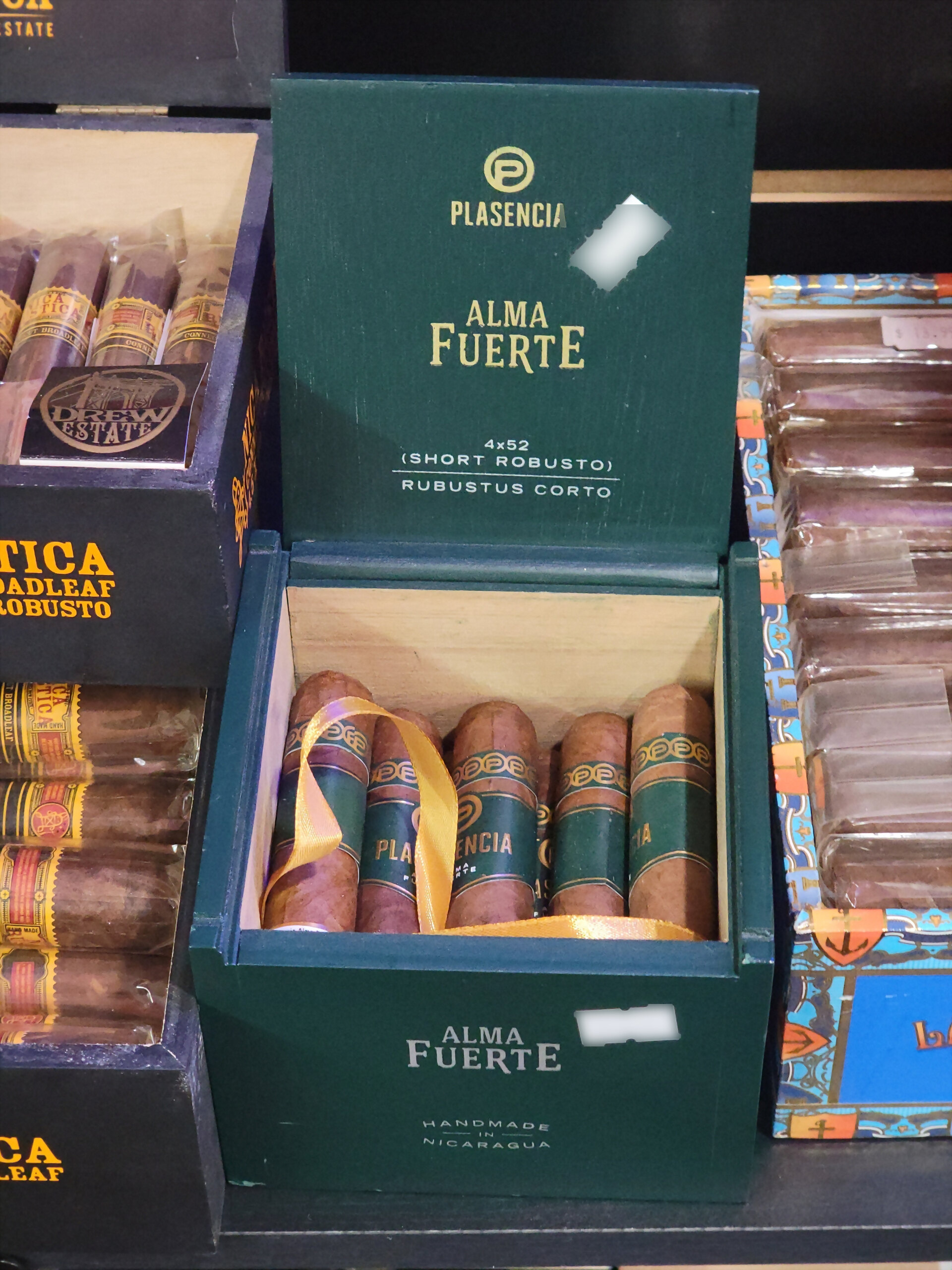 A green Plasencia Alma Fuerte Short Robusto box open on the shelf